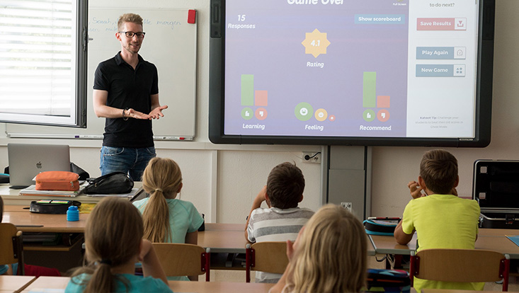 Schulklasse mit Reihenanordnung der Tische, Frontalunterricht (mit Smartboard).